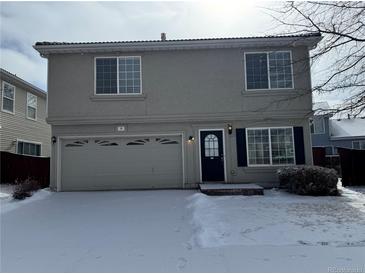 Charming two-story home with attached garage and snowy front yard at 20000 E Mitchell Pl # 39, Denver, CO 80249