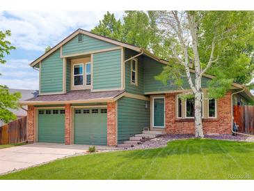 Charming two-story home with a well-maintained lawn and mature trees at 10966 W Half Moon Pass, Littleton, CO 80127