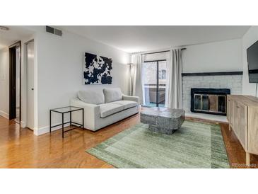 Cozy living room with a fireplace and sliding glass doors to a balcony or patio space at 4671 S Decatur St # 232, Englewood, CO 80110