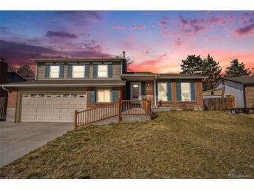 Charming two-story home with brick accents, green shutters, landscaped lawn, and driveway at 11073 Newland St, Westminster, CO 80020