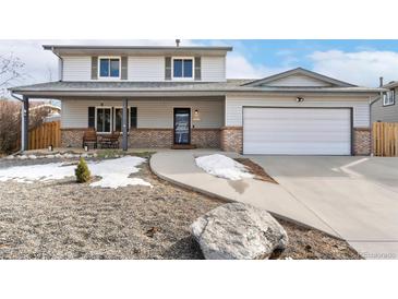 Charming two-story home boasts a covered porch, updated garage door and rock landscaping at 11936 W Temple Dr, Morrison, CO 80465