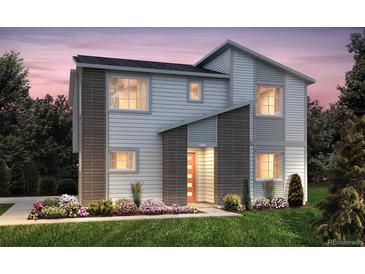 Modern two-story home featuring charming accents, lush landscaping, and a welcoming entrance at 23991 E 40Th Ave, Aurora, CO 80019