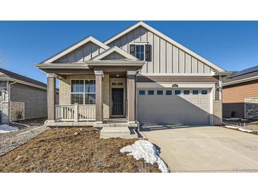 Two-story craftsman style home with gray siding, brick accents and a two-car garage at 5015 N Quemoy St, Aurora, CO 80019