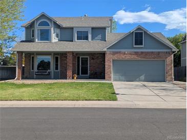 Charming two-story home with brick accents, a covered porch and well-maintained front lawn at 982 E 130Th Cir, Thornton, CO 80241