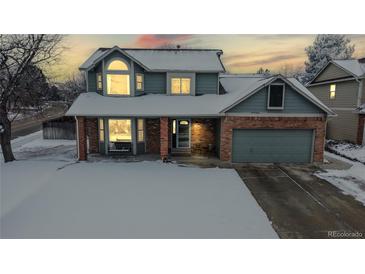 Lovely home featuring large windows, brick accents, and a cozy porch at 982 E 130Th Cir, Thornton, CO 80241