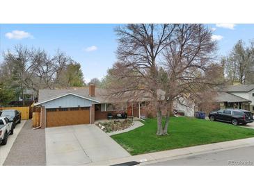 Charming single-story home with a well-maintained lawn, mature trees, and an attached two-car garage at 1359 S Brentwood Way, Lakewood, CO 80232