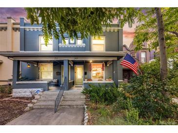 Charming painted brick duplex with a covered front porch, American flag, and landscaped front yard at 249 S Lincoln St, Denver, CO 80209