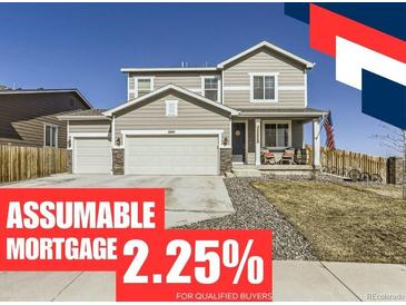 Inviting two-story home featuring a three-car garage and a charming front porch, creating a welcoming curb appeal at 5995 Fencerow Pl, Brighton, CO 80601