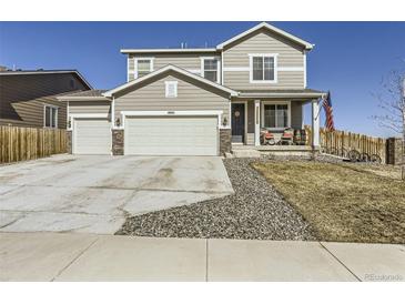 Charming two-story home featuring a three-car garage, inviting front porch, and beautiful curb appeal at 5995 Fencerow Pl, Brighton, CO 80601