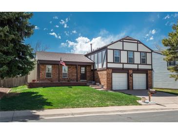 Beautiful two-story home with brick accents, an attached garage, and a lush green lawn at 15930 E Ford Pl, Aurora, CO 80017
