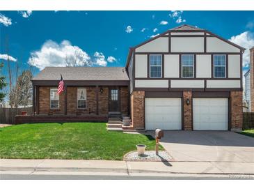 Charming two-story home with brick facade, manicured lawn, and attached two-car garage at 15930 E Ford Pl, Aurora, CO 80017