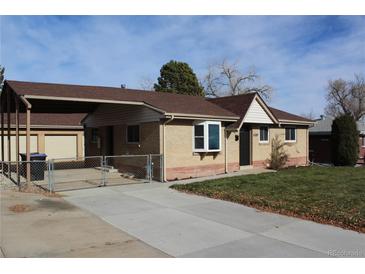 A lovely single-story home with brick exterior, fenced yard, and attached carport at 6087 W 61St Pl, Arvada, CO 80003