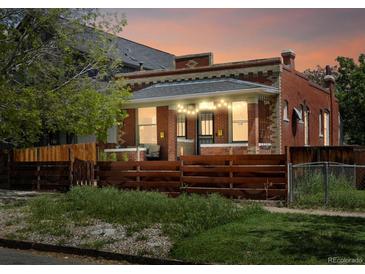 Charming brick home with string lights, a wooden fence, and a cozy front porch at sunset at 3914 Osage St, Denver, CO 80211