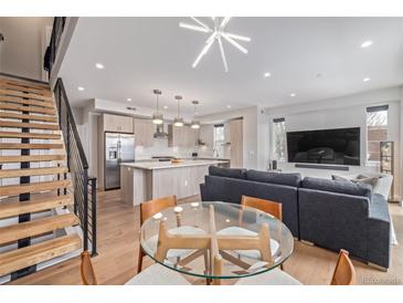 Bright, open-concept living room with modern finishes, staircase, and stylish furnishings at 2350 Tremont Pl # 13, Denver, CO 80205