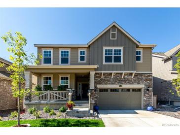 Charming two-story home with a covered porch and stone accents on the garage at 24326 E Ohio Dr, Aurora, CO 80018