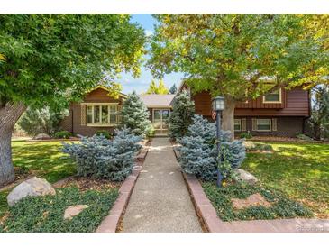 Charming two-story home with brick accents, mature trees, and manicured front yard at 7346 S Platte Canyon Dr, Littleton, CO 80128