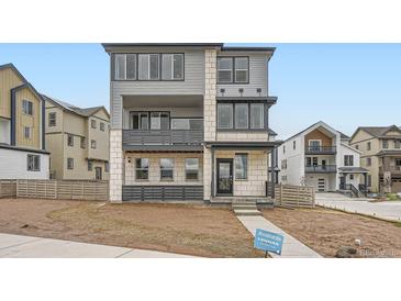 Modern three-story home featuring a mixed material facade with a balcony and an inviting entrance at 8846 Waterleaf Ln, Littleton, CO 80125