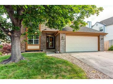 Charming brick home with a well-maintained lawn and mature shade tree at 9614 W Powers Cir, Littleton, CO 80123