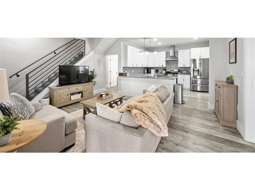 Open-concept living room and kitchen featuring modern design and stainless steel appliances at 800 S Krameria St, Denver, CO 80224