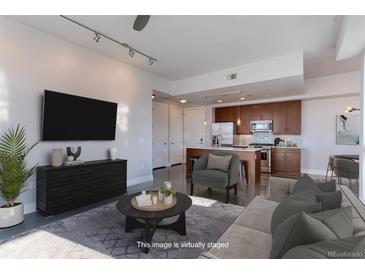Open-concept living room flows into a modern kitchen with stainless steel appliances and stylish furnishings at 2460 W 29Th Ave # 303, Denver, CO 80211