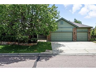 Charming two-story home with a well-manicured lawn, mature trees, and a three car garage at 2130 Chestnut Cir, Erie, CO 80516