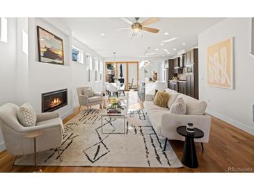 Bright open-plan living room with modern furnishings, fireplace, and hardwood floors at 845 Eudora St, Denver, CO 80220