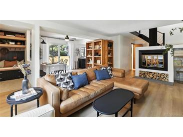 Bright living room features a leather sectional, fireplace and dining area at 6795 E Arizona Ave # B, Denver, CO 80224