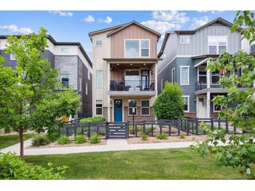Charming two-story home featuring a fenced yard, balcony and a vibrant blue front door at 8883 Ramblestone St, Highlands Ranch, CO 80129