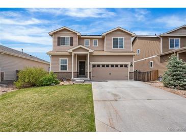 Two-story home showcasing neutral siding, a well-manicured lawn, and an attached two-car garage with a long driveway at 9535 Dexter Ln, Thornton, CO 80229