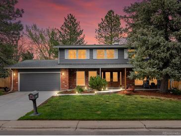 Charming two-story home featuring a well-manicured front yard at dusk at 5845 W Portland Dr, Littleton, CO 80128