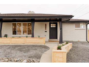 Charming home exterior with black trim, light brick, manicured landscaping, and welcoming front door at 4395 Newland St, Wheat Ridge, CO 80033