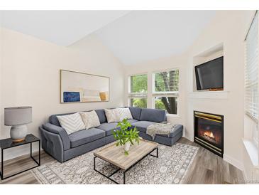 Vaulted living room with a comfortable sofa, indoor fireplace, and a great view of the outdoors at 2017 N Fork Dr, Lafayette, CO 80026