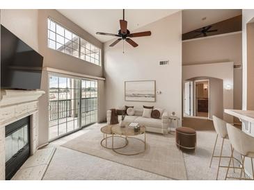 Bright living room featuring a fireplace, plush rug, and balcony access with sliding glass doors at 9481 E Mansfield Ave # 305, Aurora, CO 80014