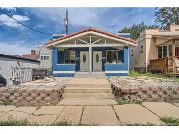 Charming blue duplex with a red tile roof and manicured front yard with stone landscaping at 2838 Decatur St, Denver, CO 80211