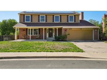 Charming two-story home with a brick and tan facade, solar panels, and a covered front porch at 3285 W 11Th Avenue Ct, Broomfield, CO 80020