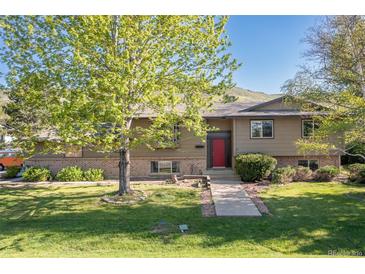 Charming home with a well-manicured lawn and mature tree in the front yard at 15000 W 29Th Ave, Golden, CO 80401