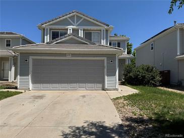 Traditional two-story home showcasing a two-car garage and concrete driveway on a bright, sunny day at 20787 E 39Th Ave, Denver, CO 80249