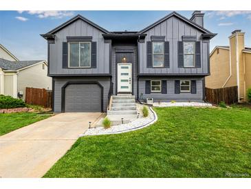 Charming two-story home with gray siding, black shutters, and a well-manicured lawn and appealing curb appeal at 19661 E Girard Ave, Aurora, CO 80013
