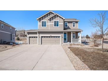 Charming two-story home featuring a three-car garage, landscaped front yard, and welcoming front porch at 5367 Spring Ridge Trl, Castle Rock, CO 80104