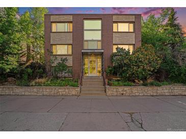 Exterior view of building with brick facade, large windows, and landscaped entryway at 1144 N Ogden St # 304, Denver, CO 80218