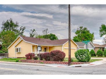 Charming yellow house featuring a well-maintained lawn and landscaping with mature bushes at 3100 S Corona St, Englewood, CO 80113