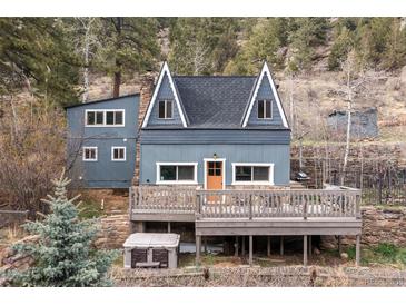 Charming mountain home featuring a spacious deck, unique architecture, and nestled amongst beautiful trees at 1264 Beaver Brook Canyon Rd, Evergreen, CO 80439