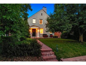 Charming two-story home with a brick walkway, lush landscaping, and inviting front porch seating at 428 N Humboldt St, Denver, CO 80218