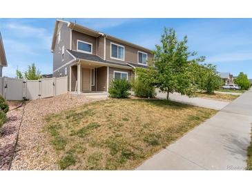 Two-story home with a manicured lawn, natural rock ground cover and a welcoming porch at 19047 Randolph Pl, Denver, CO 80249