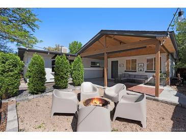 A cozy backyard setting with a fire pit and comfortable seating area under a covered patio at 9400 Ridge Rd, Arvada, CO 80002