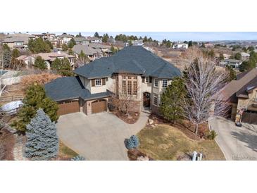 Stunning two-story home featuring a three-car garage, mature trees, and beautifully landscaped grounds at 1039 Buffalo Ridge Way, Castle Pines, CO 80108