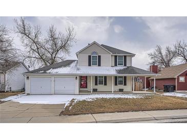 Charming two-story home with a covered porch and a three car garage at 13158 W 62Nd Dr, Arvada, CO 80004