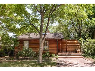 Charming home featuring wood siding, mature trees, a brick walkway, and an inviting front porch at 1878 S Gilpin St, Denver, CO 80210