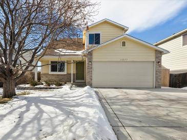 Charming two-story home with a well-maintained lawn and attached two-car garage at 13577 Quivas St, Denver, CO 80234