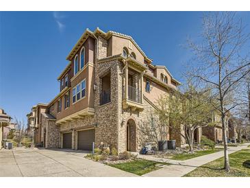 Beautiful stucco townhome with stone accents, a private balcony, and an attached two-car garage at 3370 Cascina Cir # D, Highlands Ranch, CO 80126